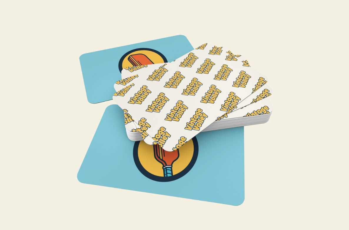 A stack of cards with "Vintage Volley" in bold yellow text on white on one side and a red-teal pickleball paddle in a yellow circle on blue on the other, fanned out to show both designs, set against a cream background.